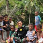 BERINTERAKSI DENGAN ANAK-ANAK PERBATASAN PAPUA, SATGAS YONIF 126/KC BERCERITA DAN BAGI BUKU