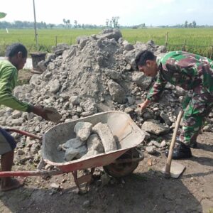 Babinsa Berikan Semangat Kepada Warga Saat Pembereman Jalan