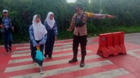 Bhabinkamtibmas Desa Citapen Polsek Ciawi Polres Bogor Bripka M. Obay Wijaya Melaksanakan Gatur Lalin Membantu Menyebrangkan Anak-Anak Sekolah