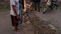Bhabinkamtibmas Lakukan Pembenahan Jalan Raya Yang Berlubang Karena Dilintasi Warga Sebagai Wujub Kemitraan