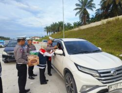 Kasat Lantas Polres Siak Bagikan Air Mineral dan Roti ke Pemudik