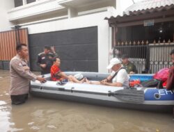 Personil Polres Metro Tangerang Kota dan Warga Bersama Evakuasi Korban Banjir di Desa Jati Mulya