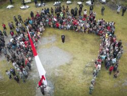 Bersama Masyarakat, Satgas Yonif 715/Motuliato dan Apkam Puncak Jaya Kibarkan Bendera Merah Putih Raksasa di Momen Tanggal 1 Mei 2025