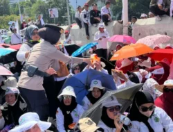 Polisi Bagikan Air Mineral dan Roti Kepada Massa Aksi Damai Guru di Silang Selatan Monas